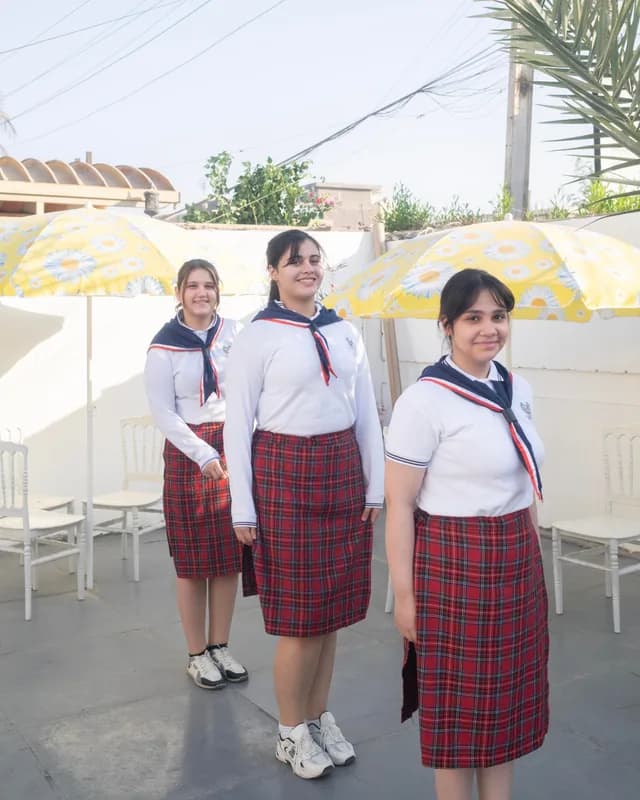 طالبات بالزي المدرسي في ساحة المدرسة